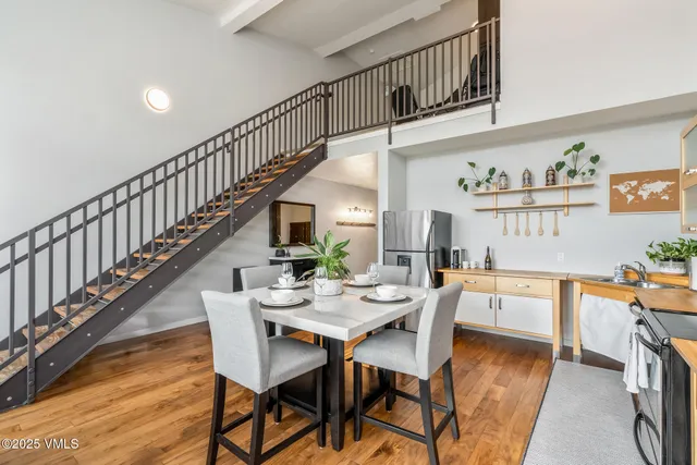 a view of a dining room with furniture a rug and wooden floor