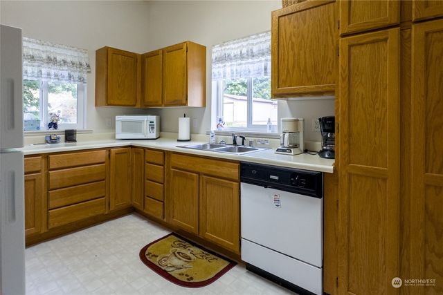 a kitchen with a sink a stove cabinets and a window