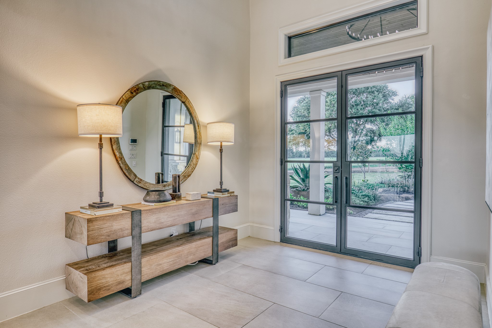 1034 Hilbun Road New Ulm, TX 78950 - Photo 22 of 49 Light-filled and sophisticated, the entry features steel-framed glass doors, expansive ceiling heights, and thoughtfully curated finishes that blend modern elegance with Texas farmhouse charm.
