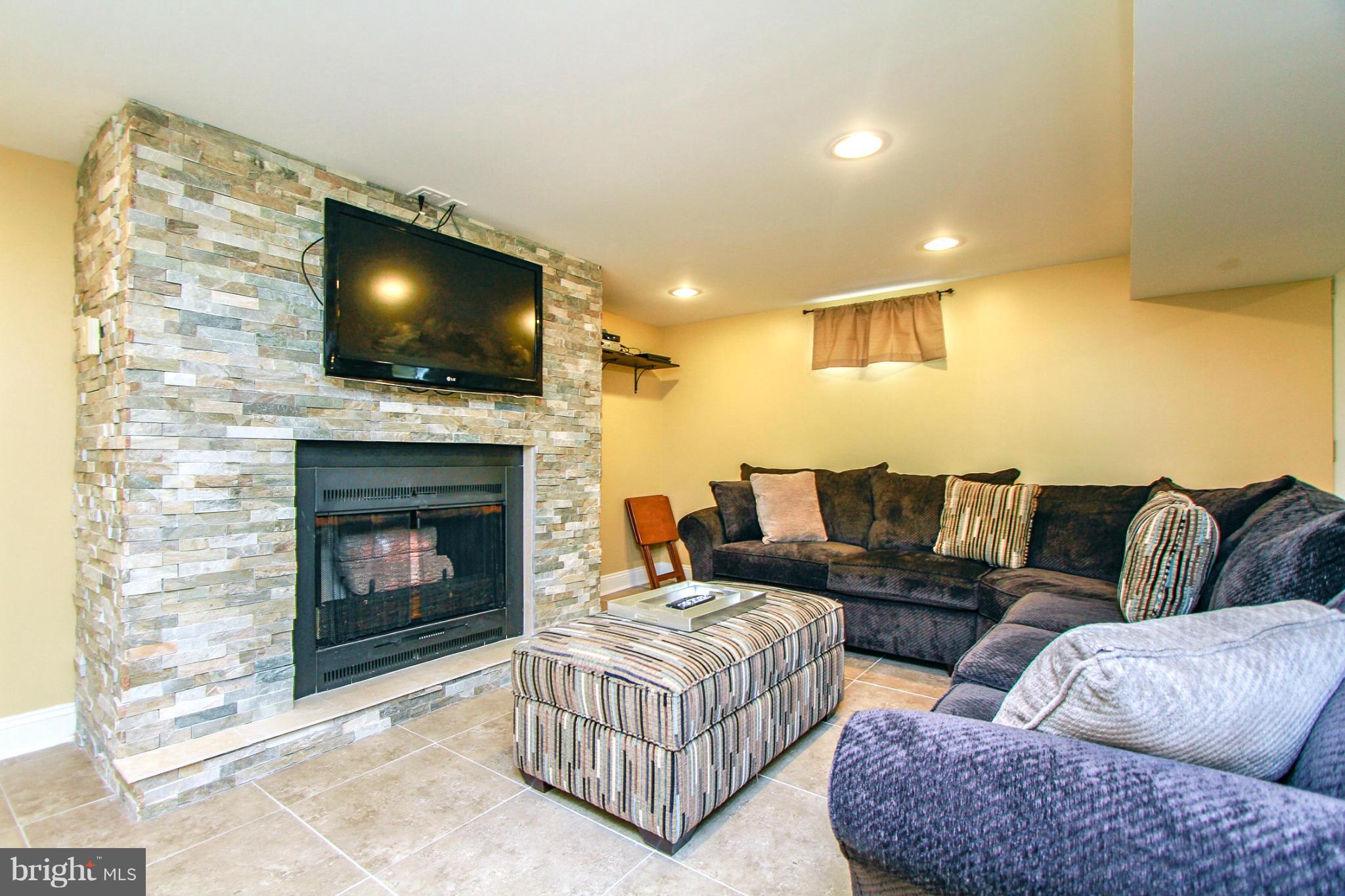 6202 Collinsway Road Baltimore, MD 21228 - Photo 18 of 30 a living room with furniture a flat screen tv and a fireplace