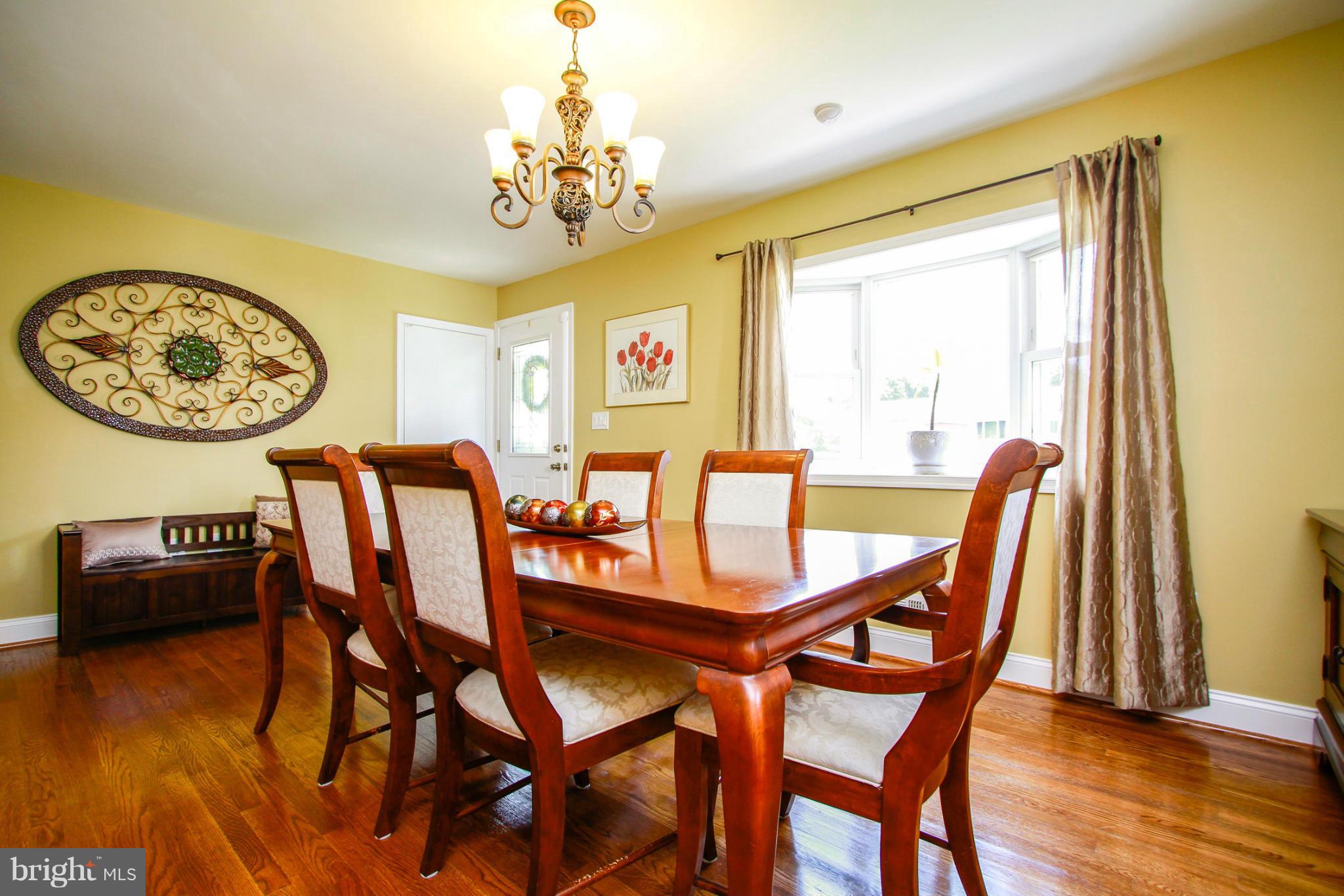 6202 Collinsway Road Baltimore, MD 21228 - Photo 4 of 30 a view of a dining room with furniture wooden floor and chandelier
