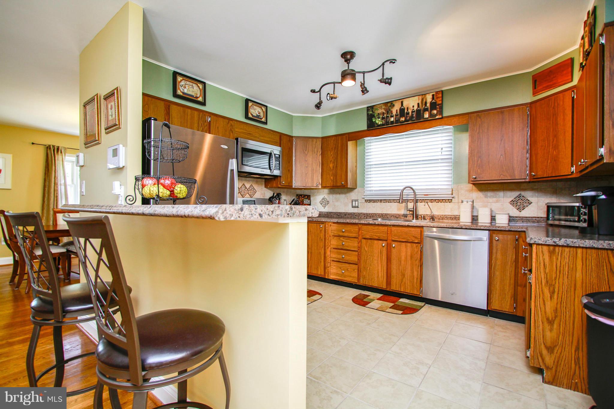 6202 Collinsway Road Baltimore, MD 21228 - Photo 8 of 30 a kitchen with a sink a stove cabinets dining table and utility