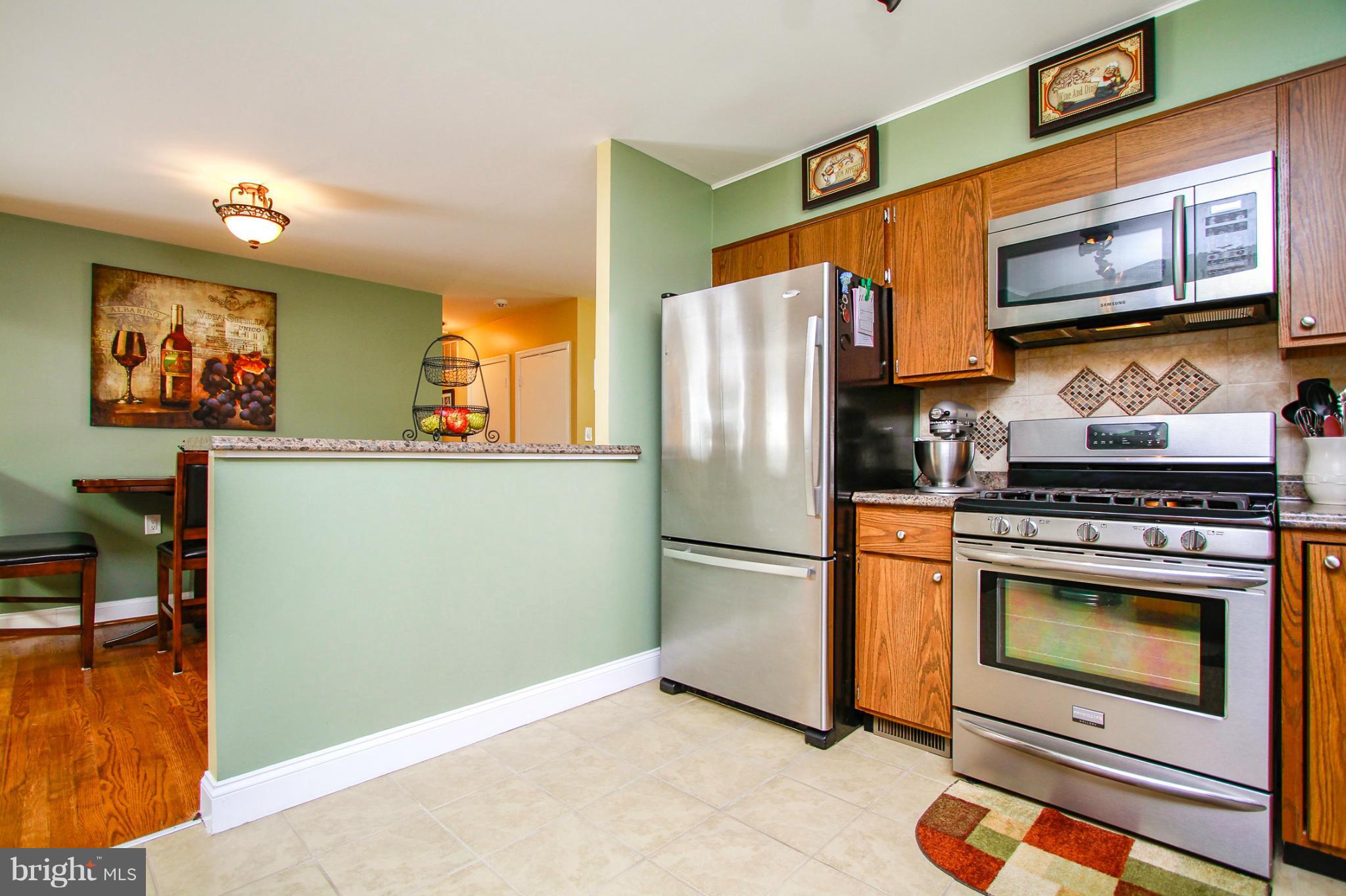 6202 Collinsway Road Baltimore, MD 21228 - Photo 9 of 30 a kitchen with stainless steel appliances granite countertop a refrigerator stove and microwave