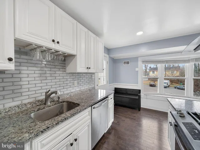 a kitchen with granite countertop a sink stainless steel appliances and cabinets