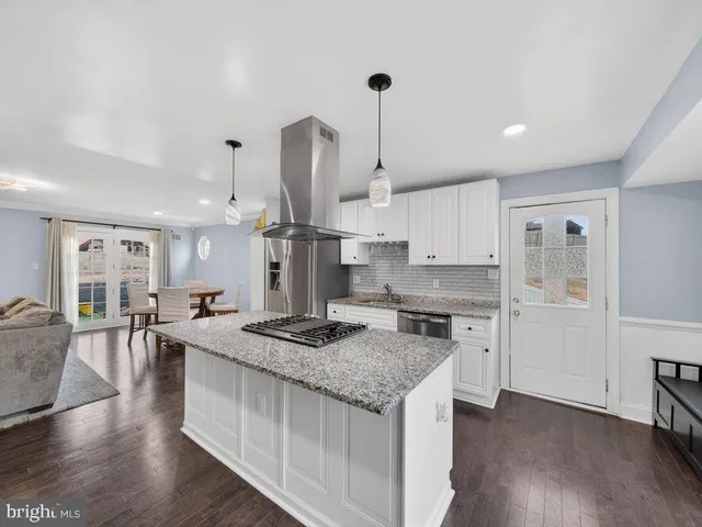 a kitchen with stainless steel appliances granite countertop a sink stove and wooden floor
