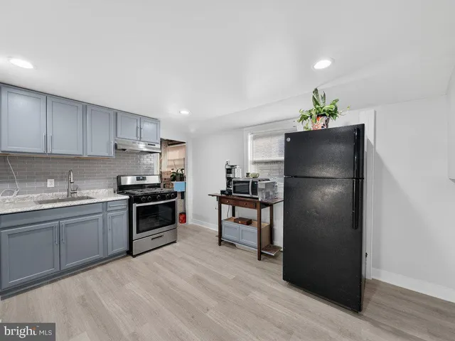 a kitchen with granite countertop a refrigerator stove and oven