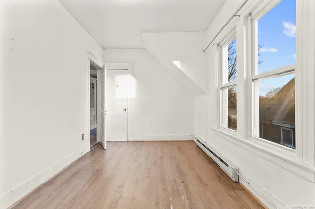 a view of a room with wooden floor and a window