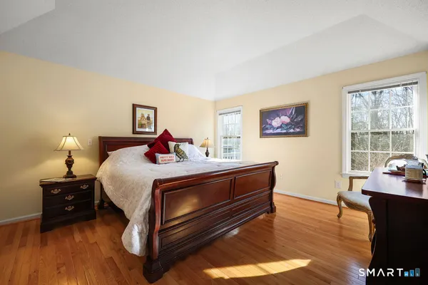 a bedroom with bed and wooden floor