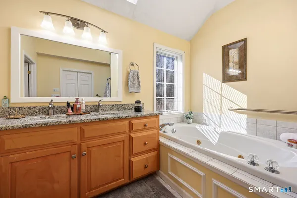 a bathroom with a tub a sink and mirror