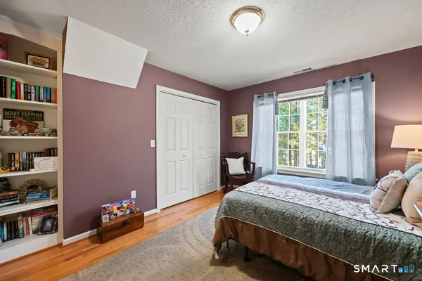 a bedroom with a bed dresser and a window