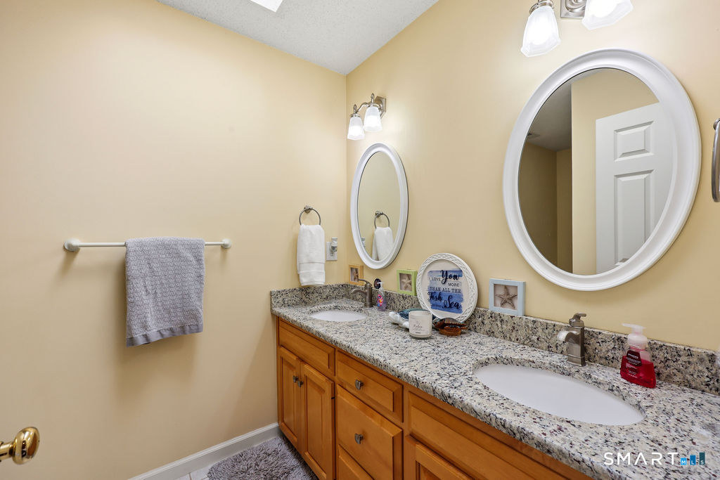 73 High Valley Drive Canton, CT 06019 - Photo 32 of 37 a bathroom with a granite countertop double vanity sink and a mirror