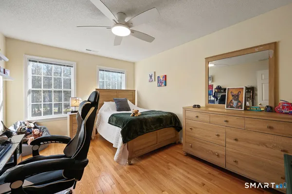 a bedroom with a bed and wooden floor