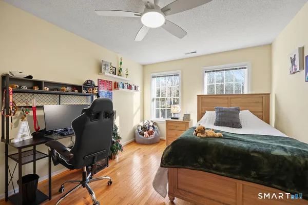 a bedroom with a bed and wooden floor
