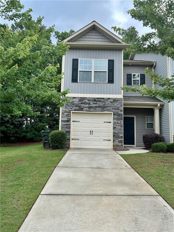 a front view of a house with a yard and garage