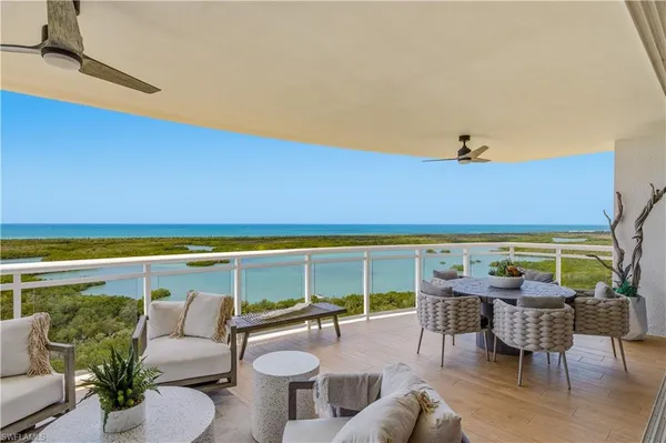 a roof deck with a table and chairs couches under an umbrella