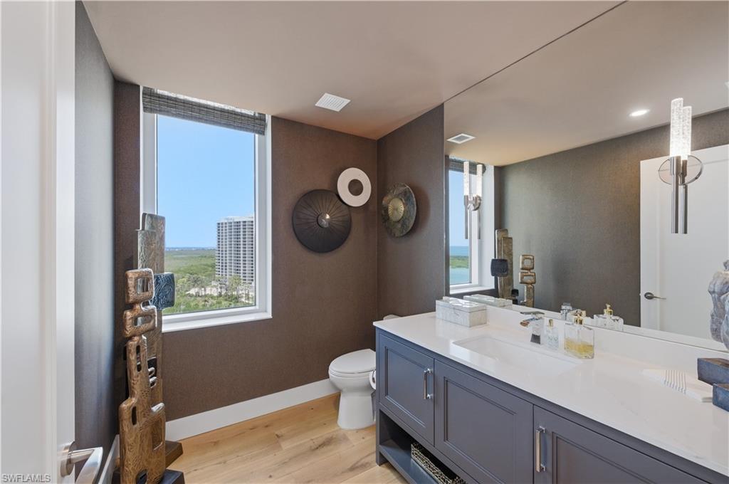 13925 Old Coast Road, Unit 1706 Naples, FL 34110 - Photo 17 of 37 a bathroom with a toilet sink and mirror
