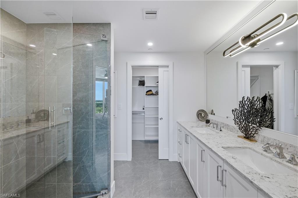 13925 Old Coast Road, Unit 1706 Naples, FL 34110 - Photo 21 of 37 a bathroom with a double vanity sink mirror and shower