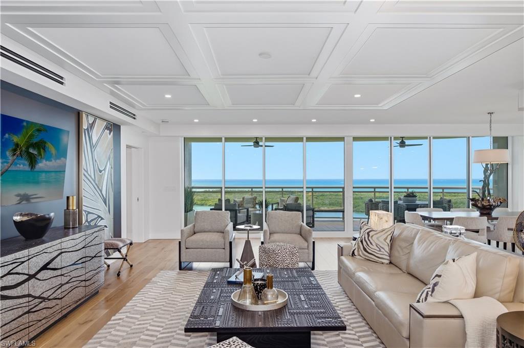 13925 Old Coast Road, Unit 1706 Naples, FL 34110 - Photo 5 of 37 a living room with furniture large windows and a table