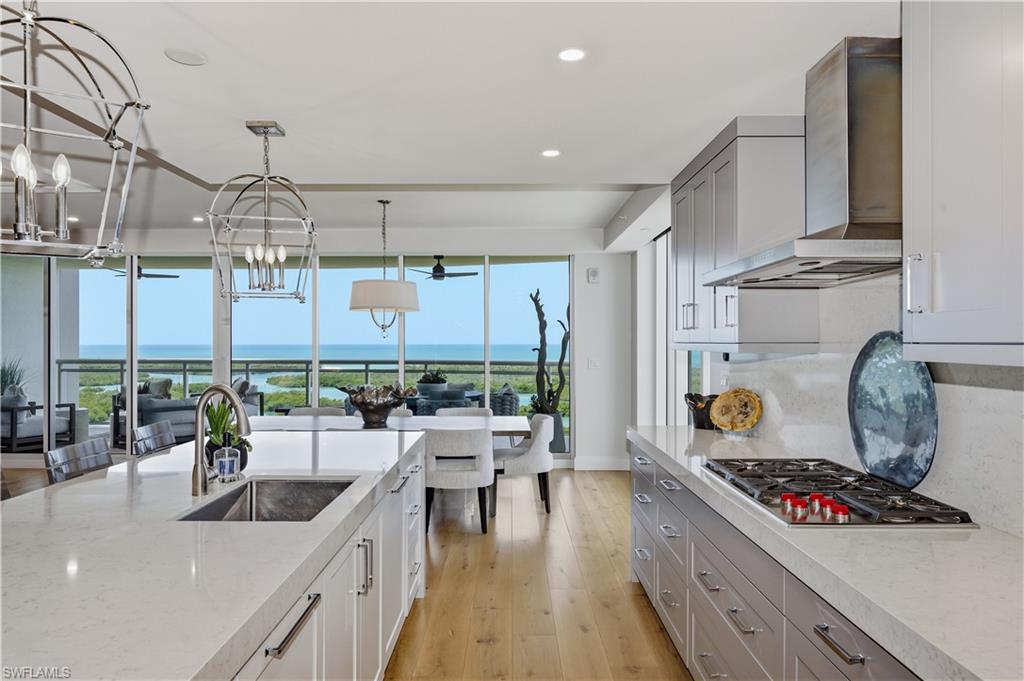 13925 Old Coast Road, Unit 1706 Naples, FL 34110 - Photo 10 of 37 a kitchen with stainless steel appliances granite countertop a stove a sink dishwasher and cabinets with wooden floor