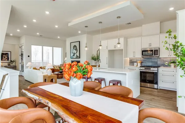 a living room with stainless steel appliances furniture fireplace and a view of kitchen