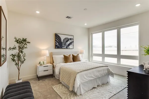 a bedroom with a large bed and a potted plant
