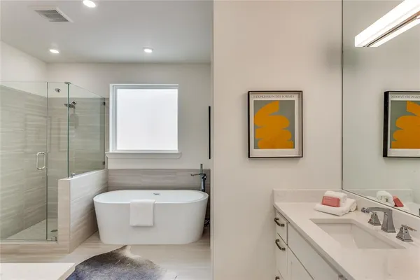 a bathroom with a tub sink and mirror