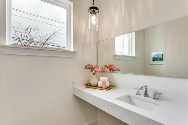 a bathroom with a sink mirror and window