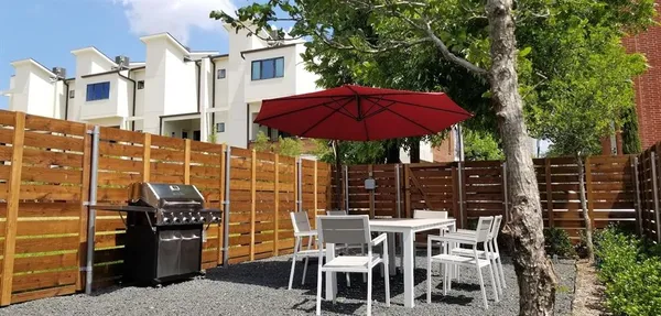 a view of a patio with table and chairs under an umbrella