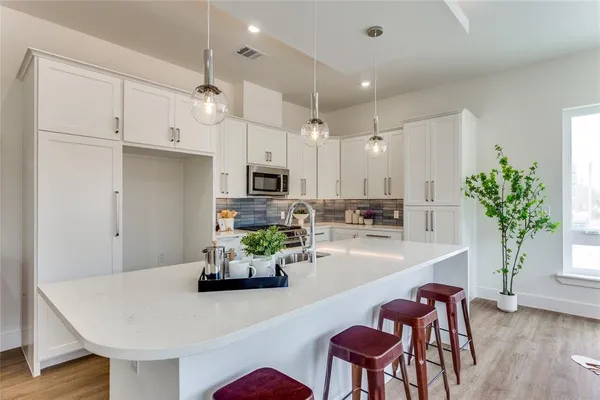 a kitchen with granite countertop white cabinets and stainless steel appliances