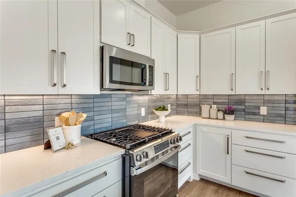 a kitchen with white cabinets and appliances