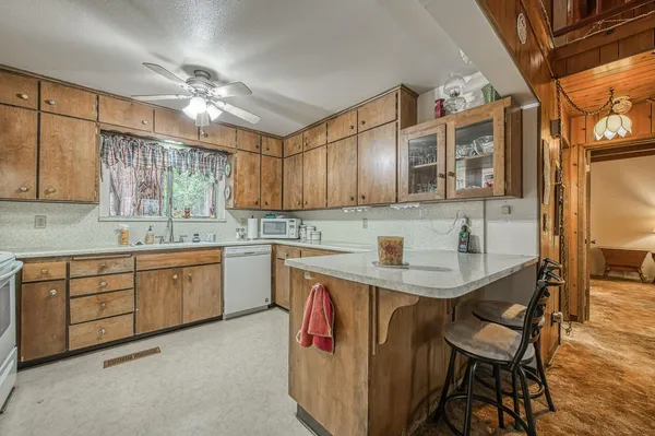 a kitchen with a sink dishwasher cabinets and white appliances