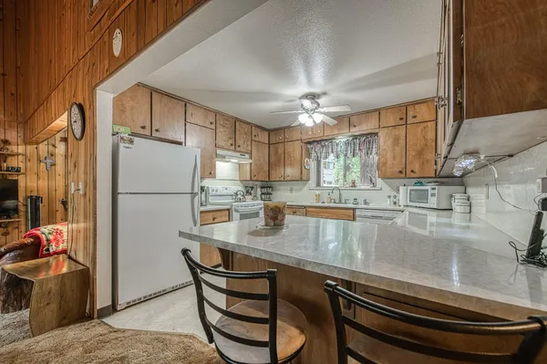 a kitchen with stainless steel appliances granite countertop a refrigerator sink stove and white cabinets