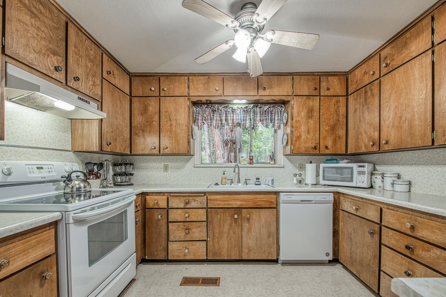 42303 Hanging Branch Road Shaver Lake, CA 93664 - Photo 17 of 39 a kitchen with a sink dishwasher cabinets and white appliances