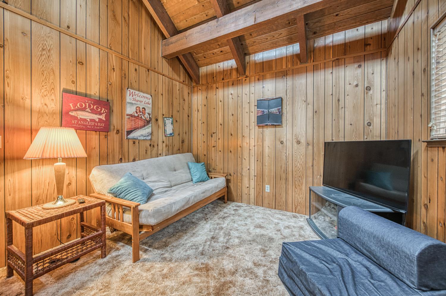 42303 Hanging Branch Road Shaver Lake, CA 93664 - Photo 29 of 39 a living room with a couch a rug and a flat screen tv