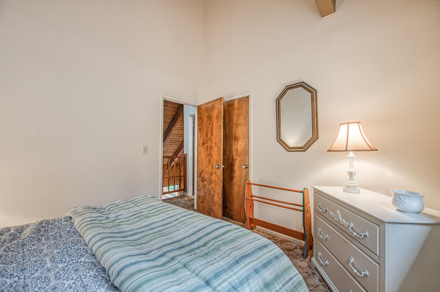 42303 Hanging Branch Road Shaver Lake, CA 93664 - Photo 31 of 39 a bedroom with a bed and a chandelier