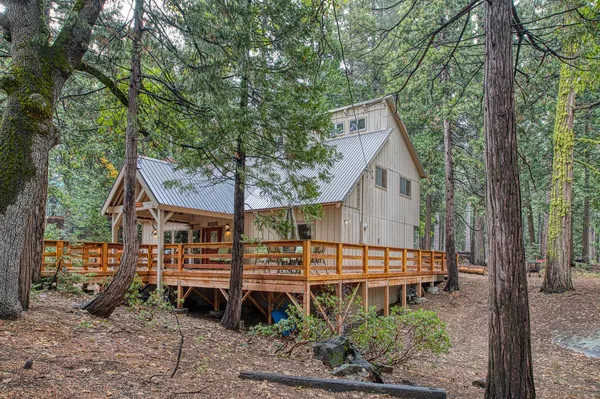 a view of backyard of house with deck and outdoor seating