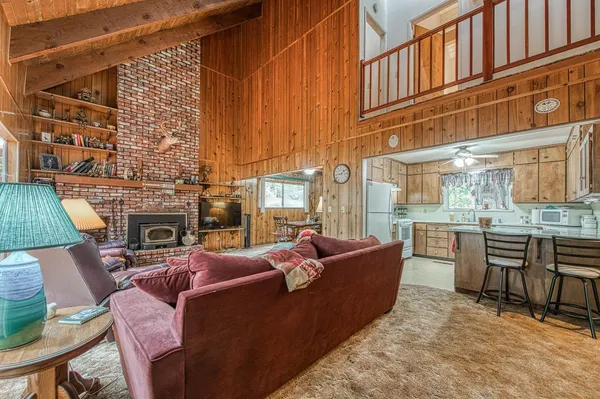 a living room with fireplace furniture and a floor to ceiling window