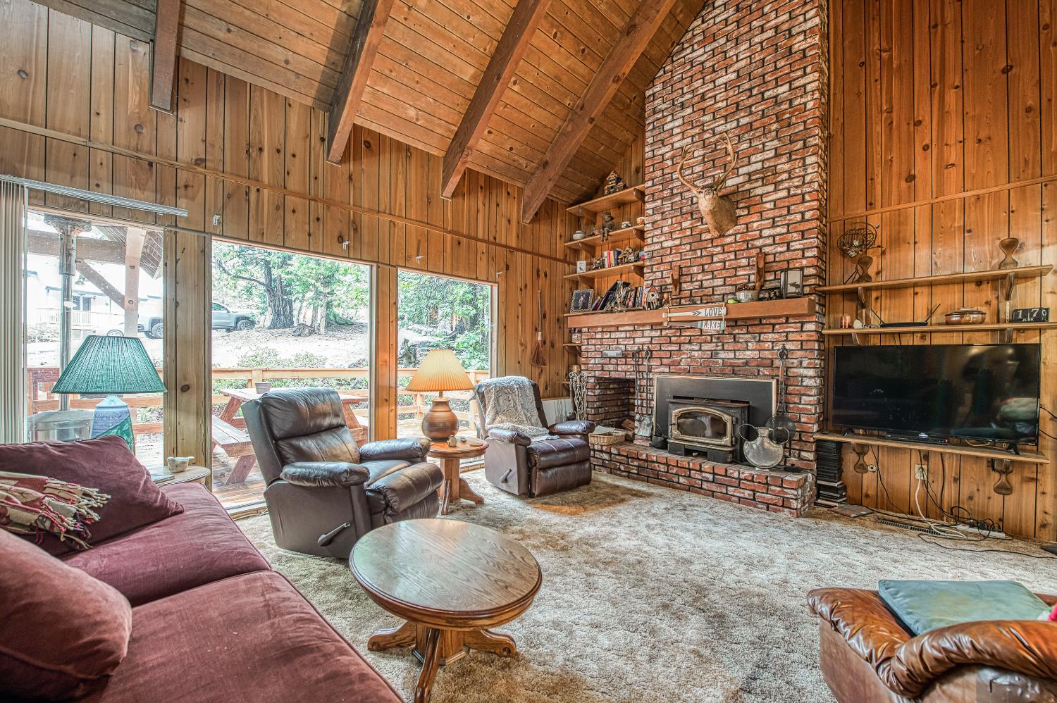 42303 Hanging Branch Road Shaver Lake, CA 93664 - Photo 9 of 39 a living room with furniture a fireplace and a flat screen tv