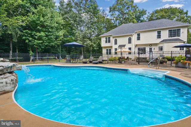a view of a house with swimming pool and sitting area