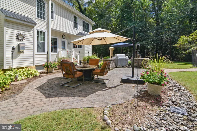 a view of a patio with a table and chairs under an umbrella