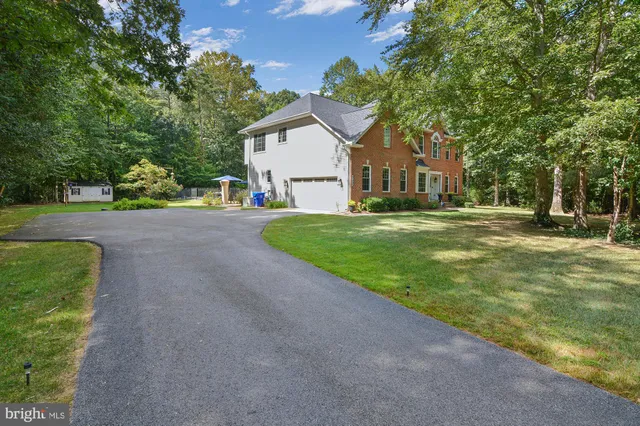 a front view of a house with a yard and trees
