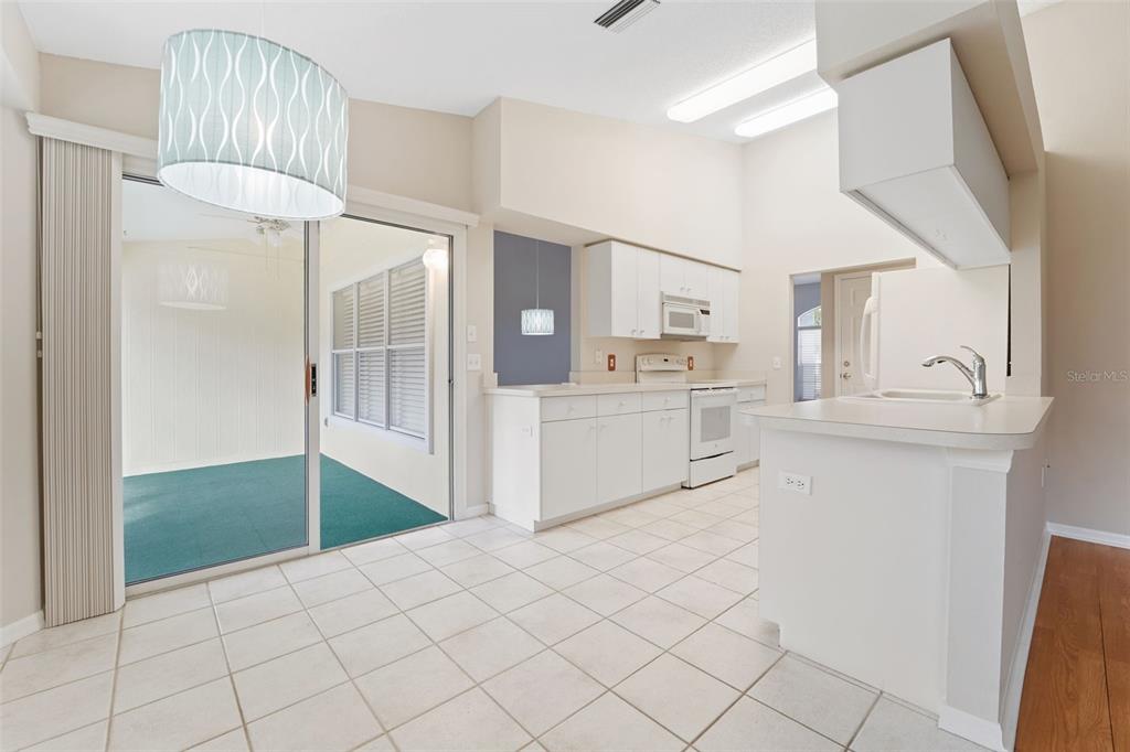 1031 Almondwood Drive Trinity, FL 34655 - Photo 13 of 49 a kitchen with white cabinets and refrigerator