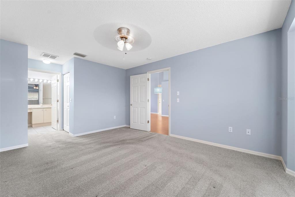 1031 Almondwood Drive Trinity, FL 34655 - Photo 16 of 49 a view of an empty room with wooden floor and a kitchen