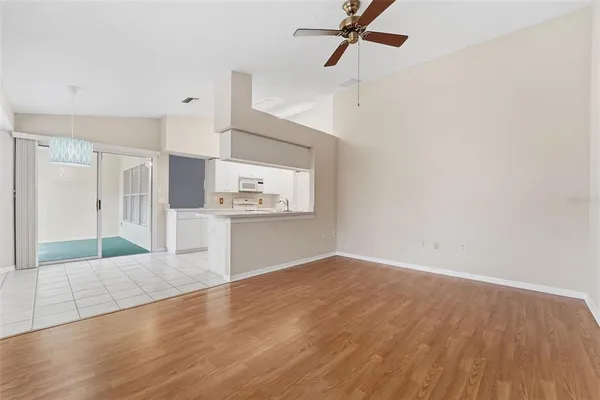 a view of a kitchen with wooden floor a sink and a refrigerator