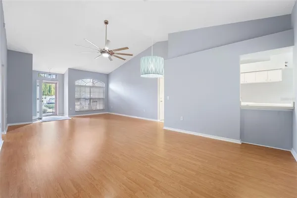 a view of an empty room with window and wooden floor