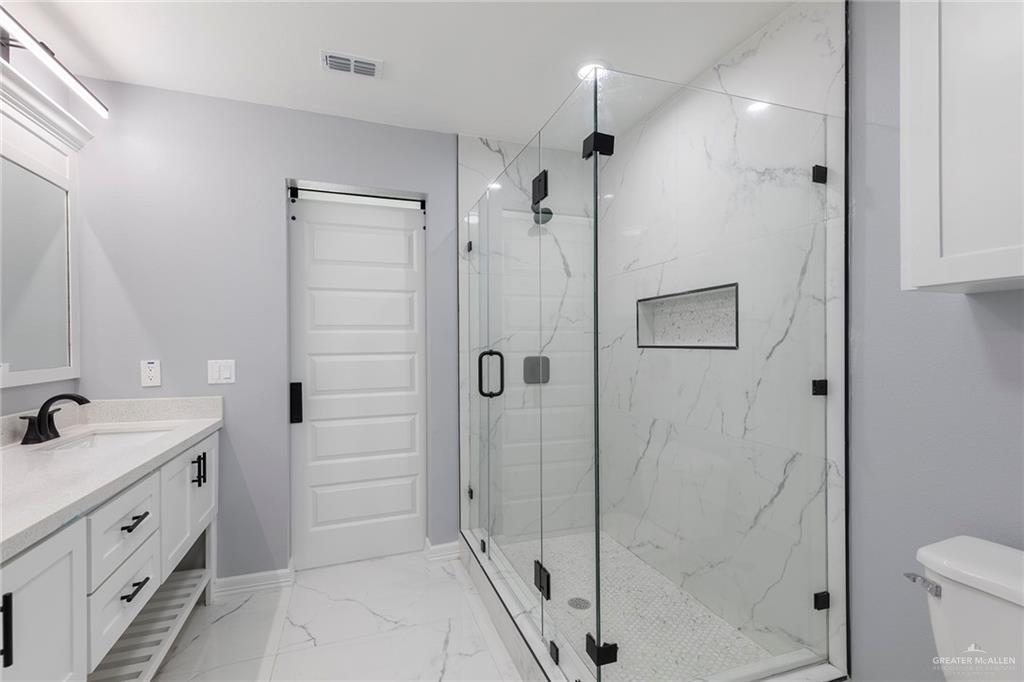 6809 South Oro Lane Pharr, TX 78577 - Photo 13 of 17 a bathroom with a shower sink and toilet