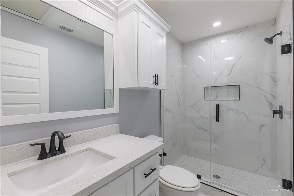 6809 South Oro Lane Pharr, TX 78577 - Photo 16 of 17 a bathroom with a sink toilet and shower
