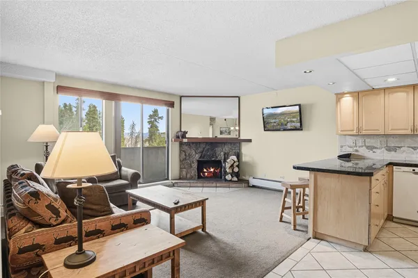 a living room with furniture a fireplace and a large window