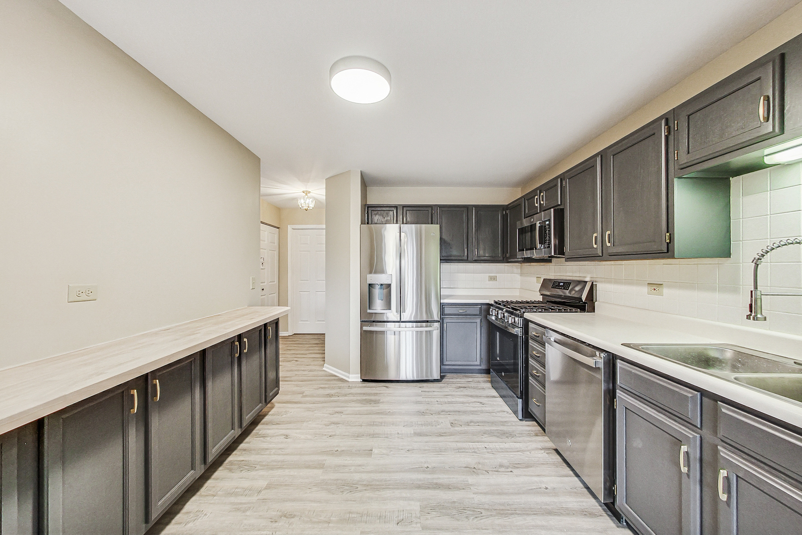1006 Butternut Lane, Unit B Mount Prospect, IL 60056 - Photo 12 of 26 a kitchen with stainless steel appliances granite countertop a sink and a stove top oven