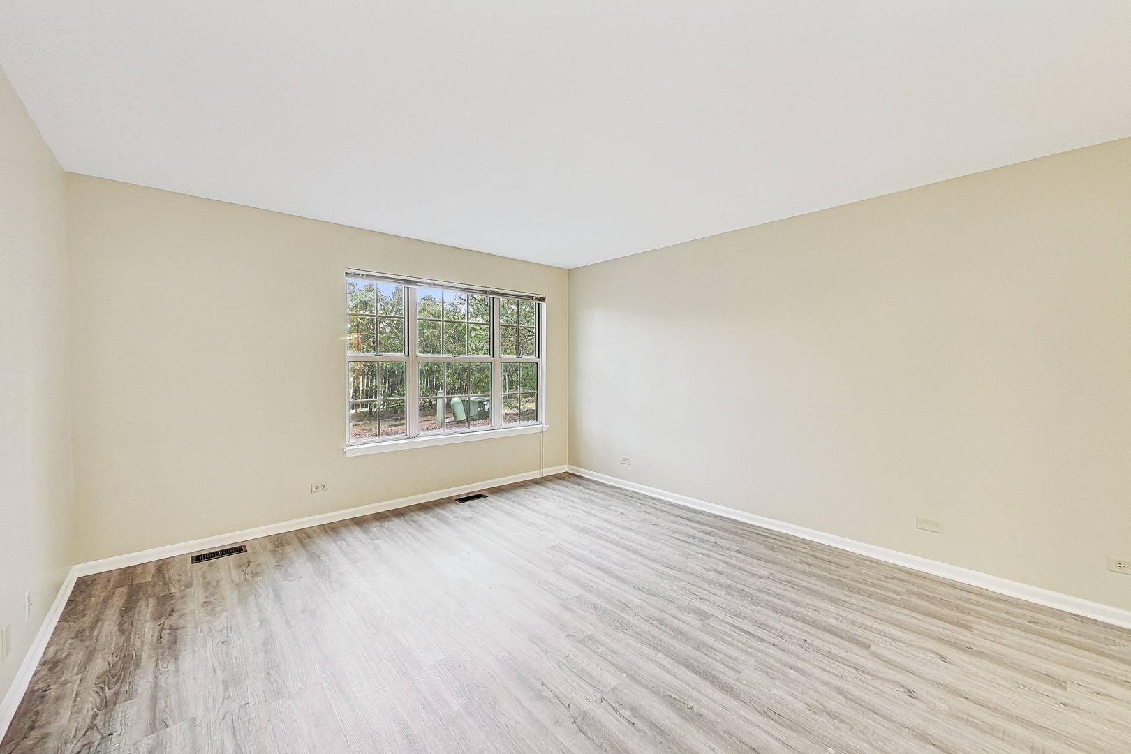 1006 Butternut Lane, Unit B Mount Prospect, IL 60056 - Photo 13 of 26 an empty room with wooden floor and windows